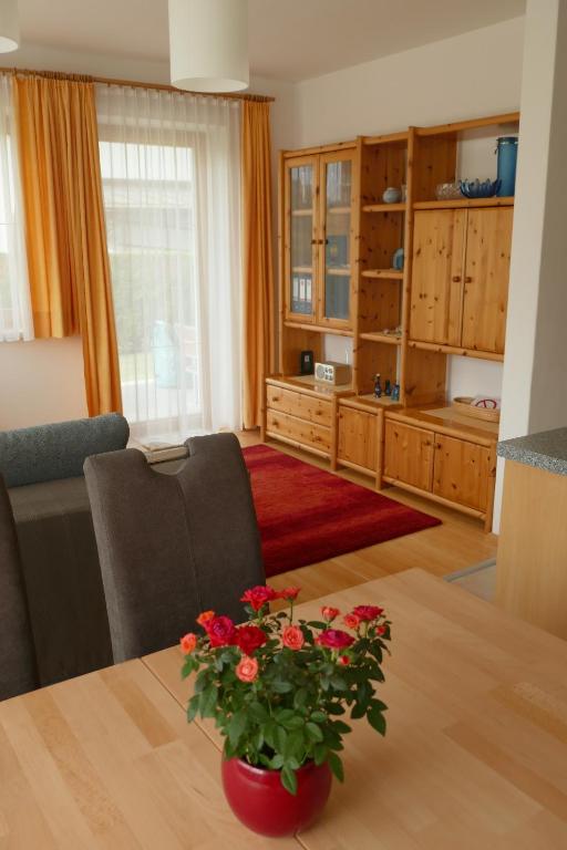 ein Wohnzimmer mit einem Tisch und einer Blumenvase in der Unterkunft Apartment Neuhauser in Kramsach