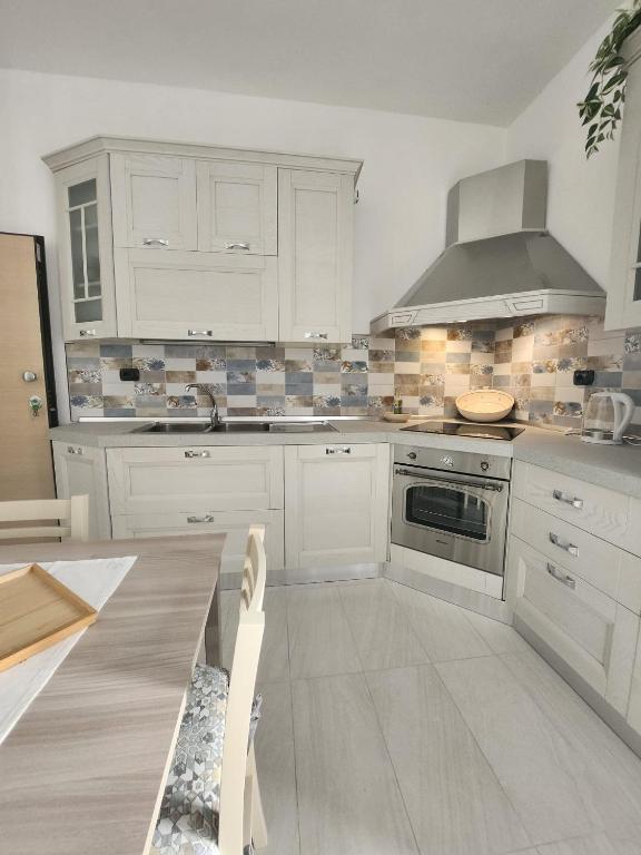 a kitchen with white cabinets and a stove top oven at Il Pizzuto - Appartamento da Nonna Anna in Bernalda