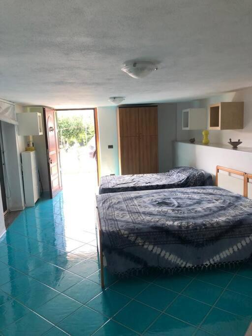 1 dormitorio con 1 cama y suelo de baldosa en Lontano dal caos, pace e verde!, en Praia a Mare
