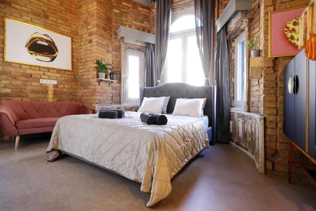 a bedroom with a bed and a brick wall at BudapeStayz - Raday Rooms in Budapest