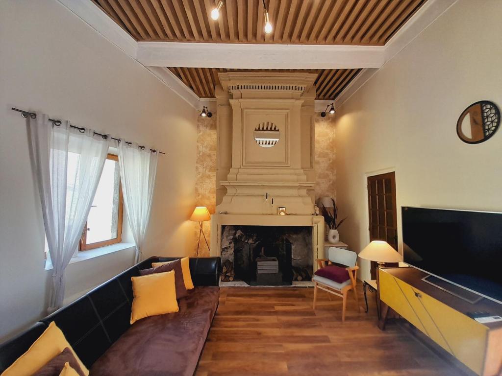 sala de estar con sofá y chimenea en "Maison du consul" avec terrasse - centre historique, en Narbona