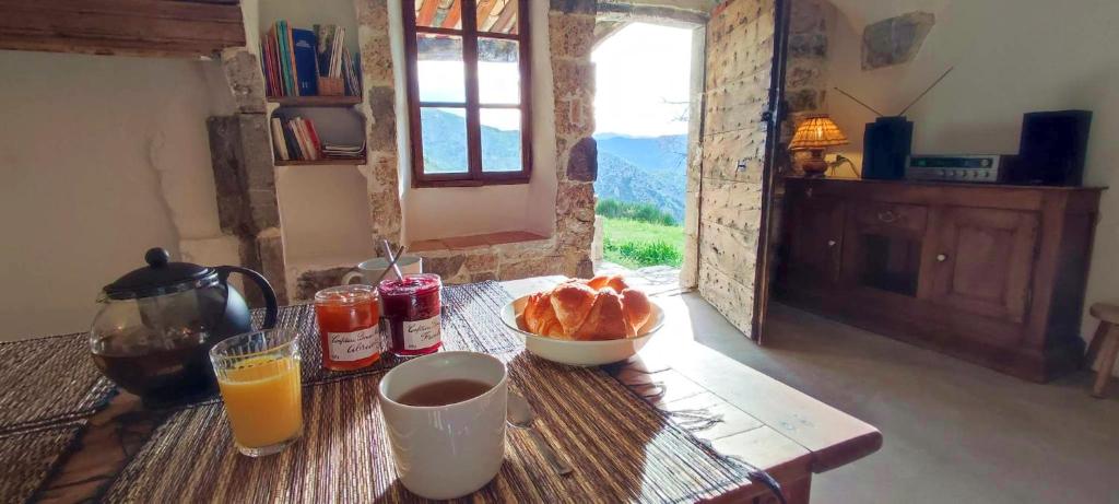 - une table avec un bol de pain et un verre de jus d'orange dans l'établissement Abbaye de Bodon - Provence, à Saint-May