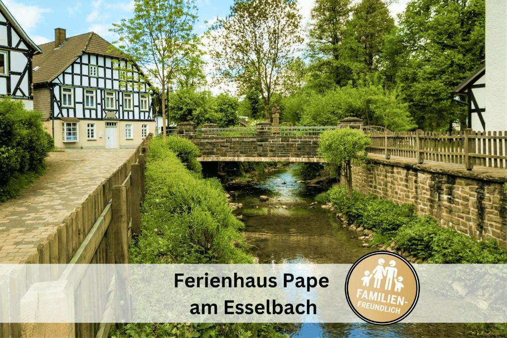 a picture of a bridge over a river with a building at Ferienhaus Pape - 300m2, 15 Betten - mit großem privatem Garten, Pool, Dart, Sauna-, Grill- und Spielbereich - Ideal für Familien in Eslohe