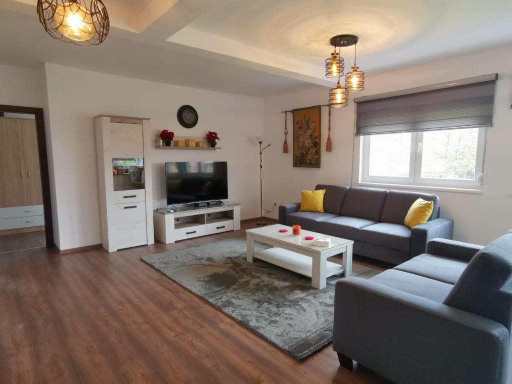 een woonkamer met een bank en een tafel bij Oasis Royal Apartments in Sarajevo