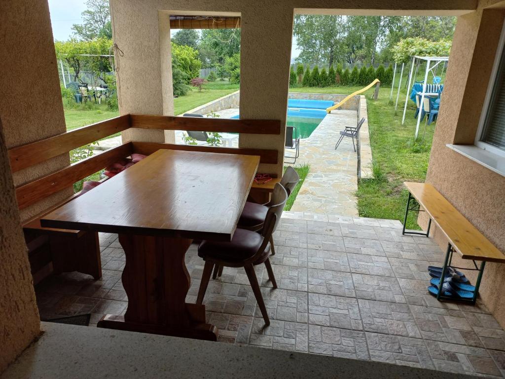 comedor con mesa y vistas a la piscina en Kuća u selu sa bilijar salom za aktivan odmor, en Mionica