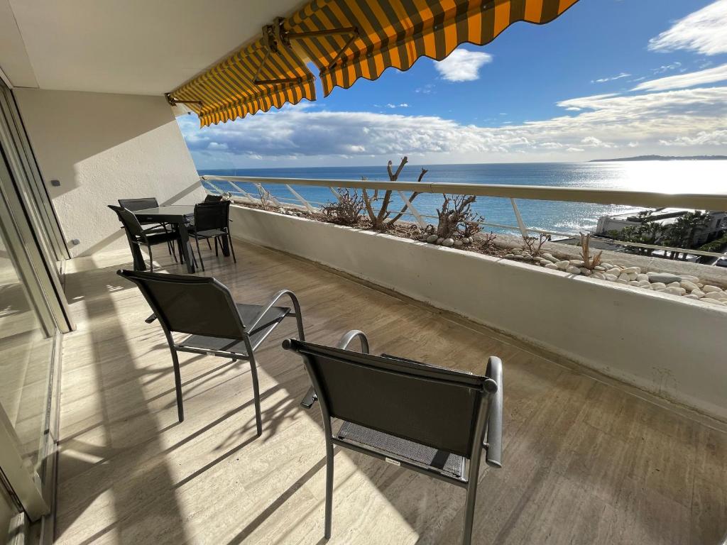 Un balcón con sillas y vistas al océano. en 06AO - Superbe appartement avec vue mer exceptionnelle, en Villeneuve-Loubet