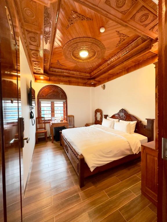 um quarto com uma cama e um tecto de madeira em Hotel Hoàng My em Pleiku