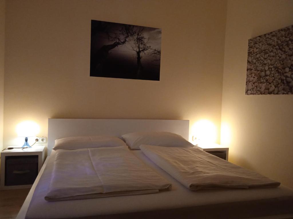 1 dormitorio con 1 cama y 2 luces en 2 mesas en Aszófői Panoráma Apartmanház, en Aszófő