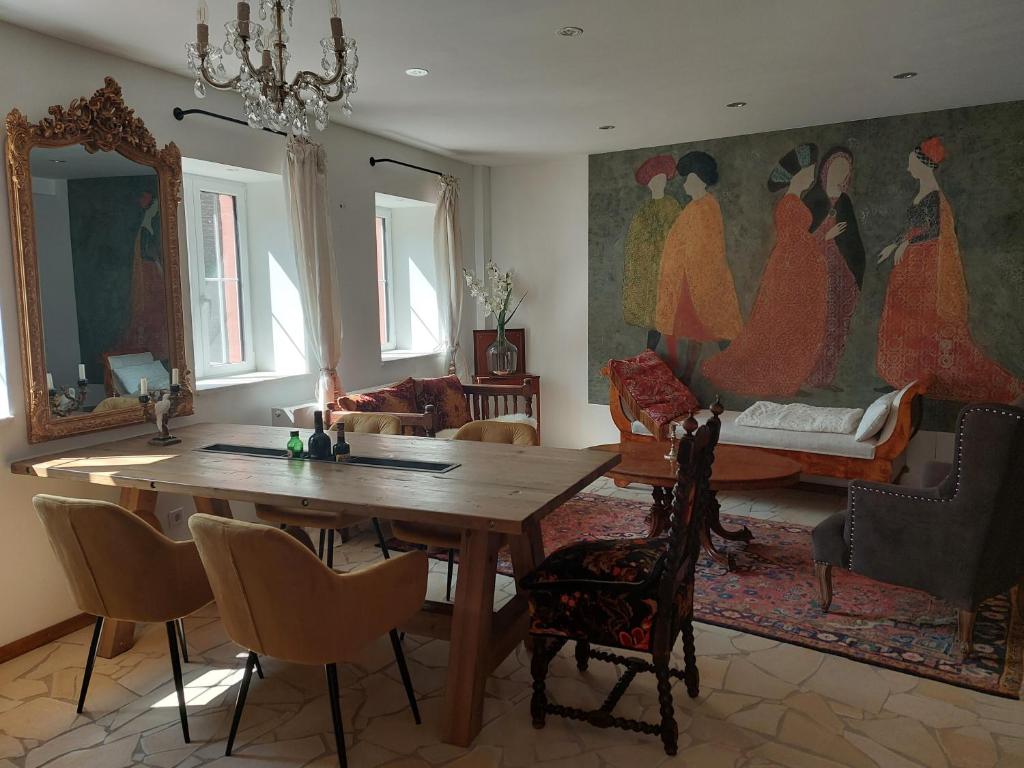 un comedor con una mesa y una pintura de mujeres en Romantisches Ferienhaus in Moselnähe en Maring-Noviand