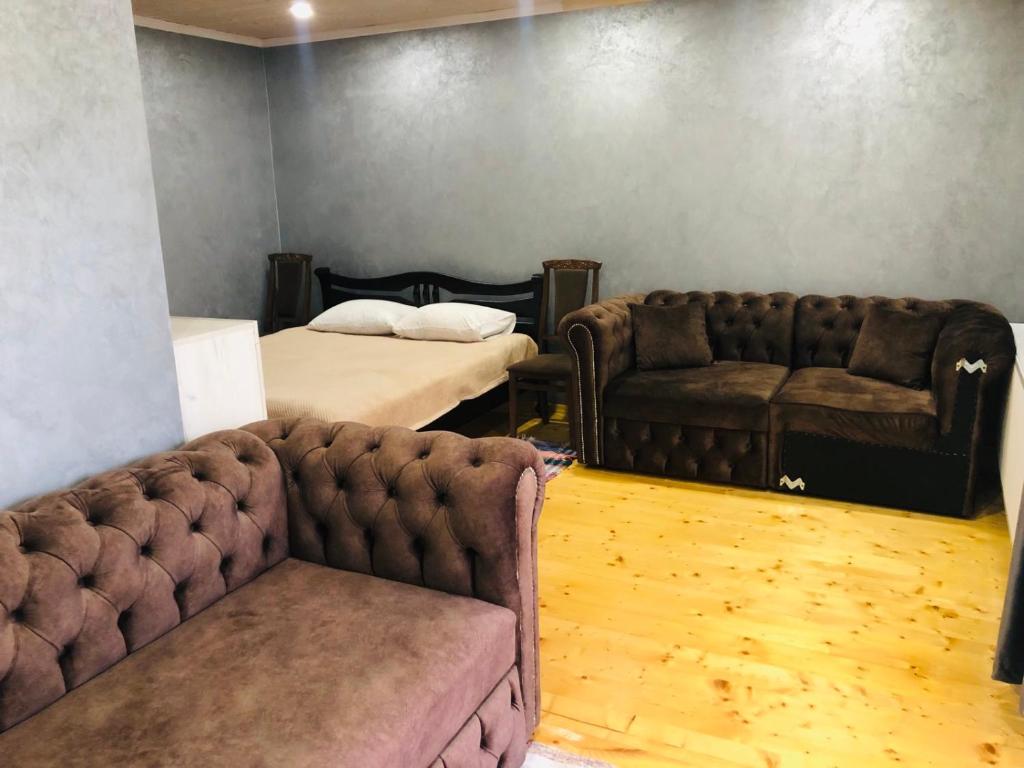 ein Wohnzimmer mit 2 Sofas und einem Bett in der Unterkunft Під лісом in Soymy