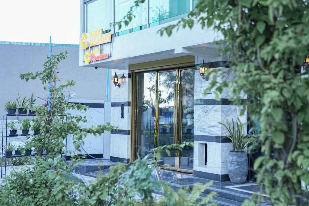 an office building with glass doors and potted plants at Sunny Canopy in Hulhumale