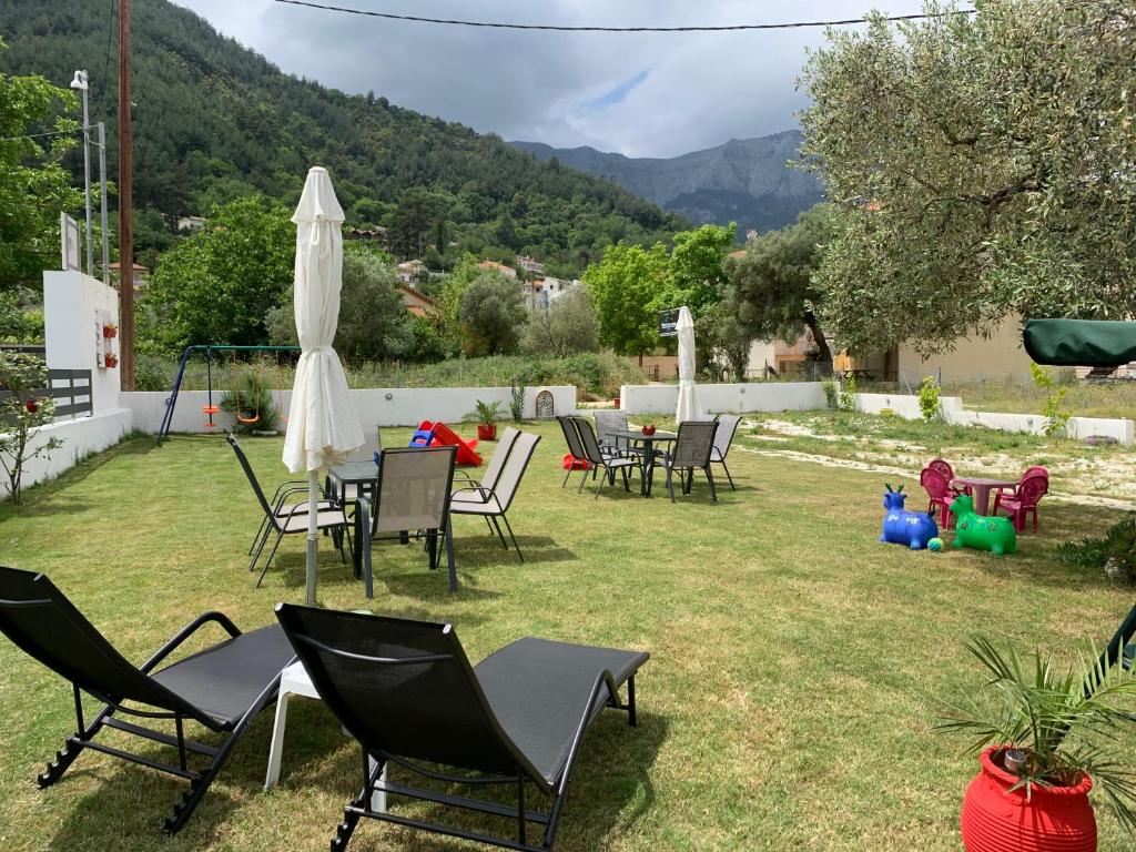 a group of chairs and umbrellas in a yard at Harmony Studios & Apartments in Skala Potamias