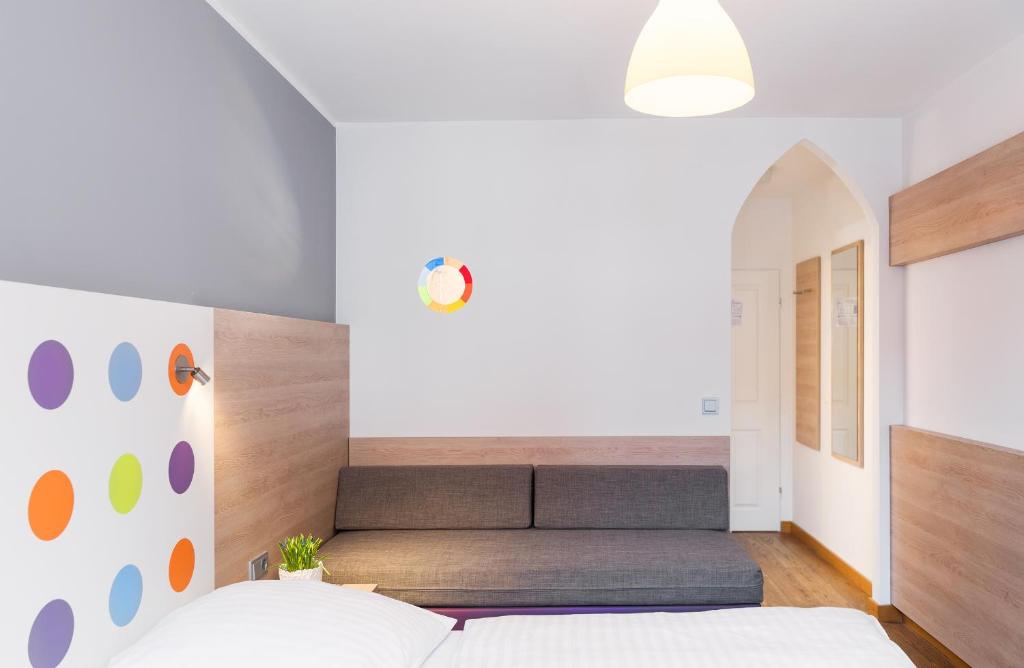 ein Schlafzimmer mit einem Bett und einem Sofa in der Unterkunft 1st Creatif Hotel Elephant in München