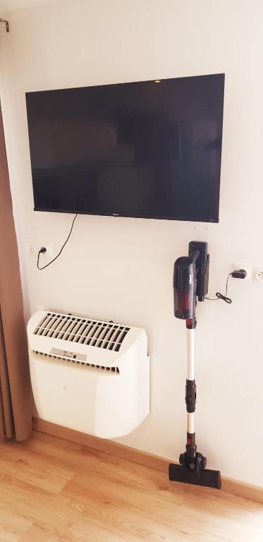 a fan and a tv on a wall with a camera at Escapade Niortaise - Studios climatisés hyper-centre de Niort in Niort
