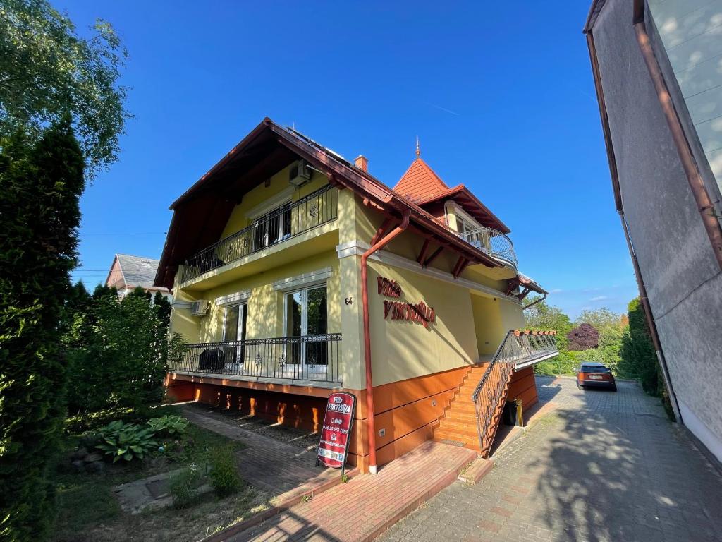 een groot huis met een balkon aan een straat bij Villa Viktoria in Hévíz