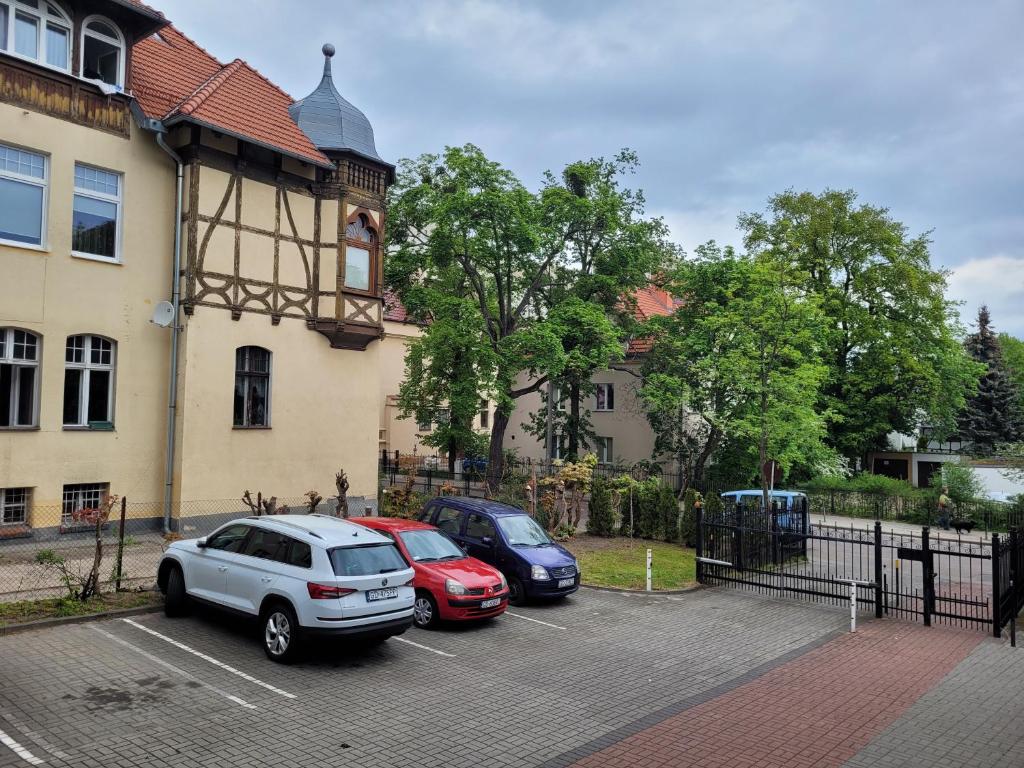 tres autos estacionados en un estacionamiento frente a un edificio en Apartament Batorego 2a en Gdansk