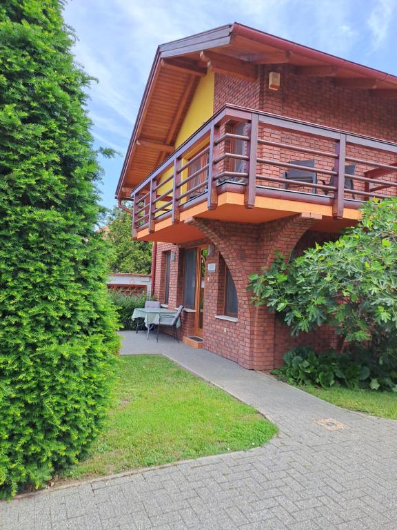 a brick building with a balcony and a bench at Rozmaring Apartmanok in Gyula