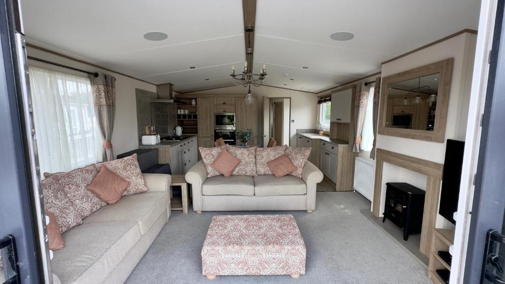 a living room with two couches and a kitchen at Luxury Hotub Lodge with Lake View at Tattershall Lakes in Tattershall