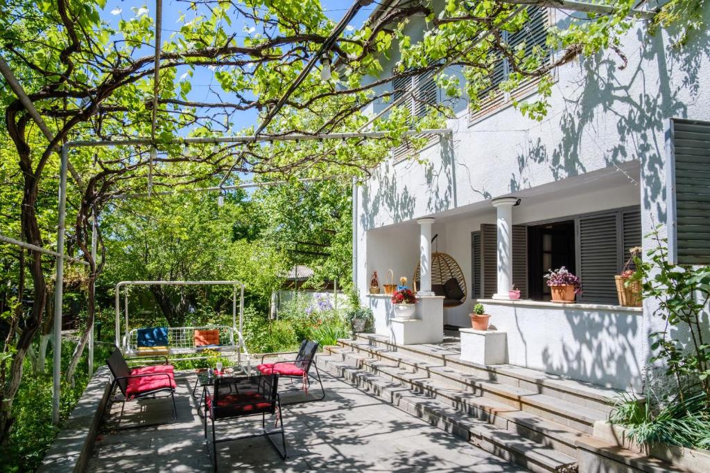 a patio with chairs and a table in a yard at Vintage Villa Saguramo 