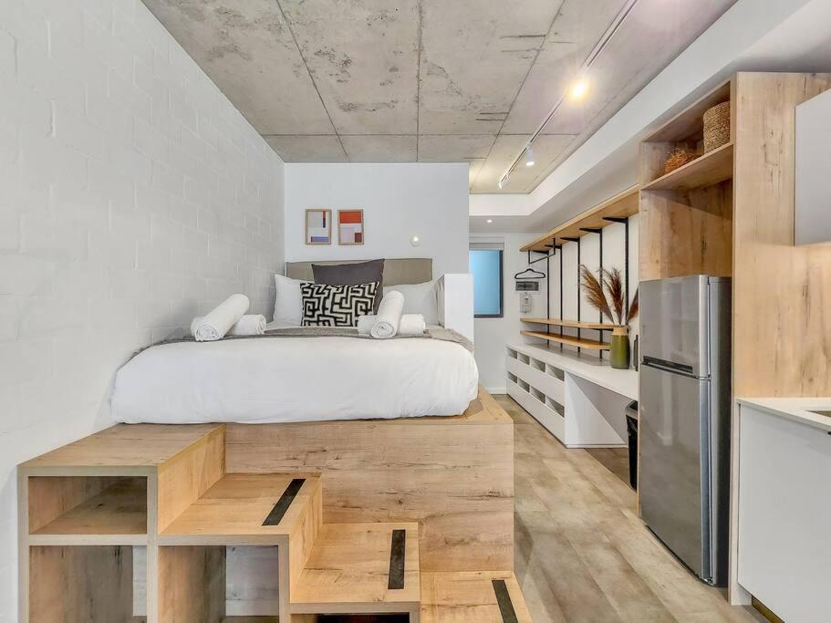 ケープタウンにあるSecure Elegant Apartment Near Sea Pointのベッドルーム1室(ベッド1台、木製テーブル付)