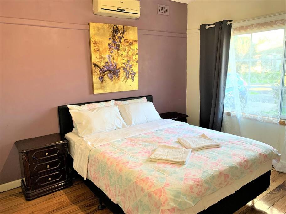 a bedroom with a bed with two books on it at Easy Self Check-in accomodation in Springvale