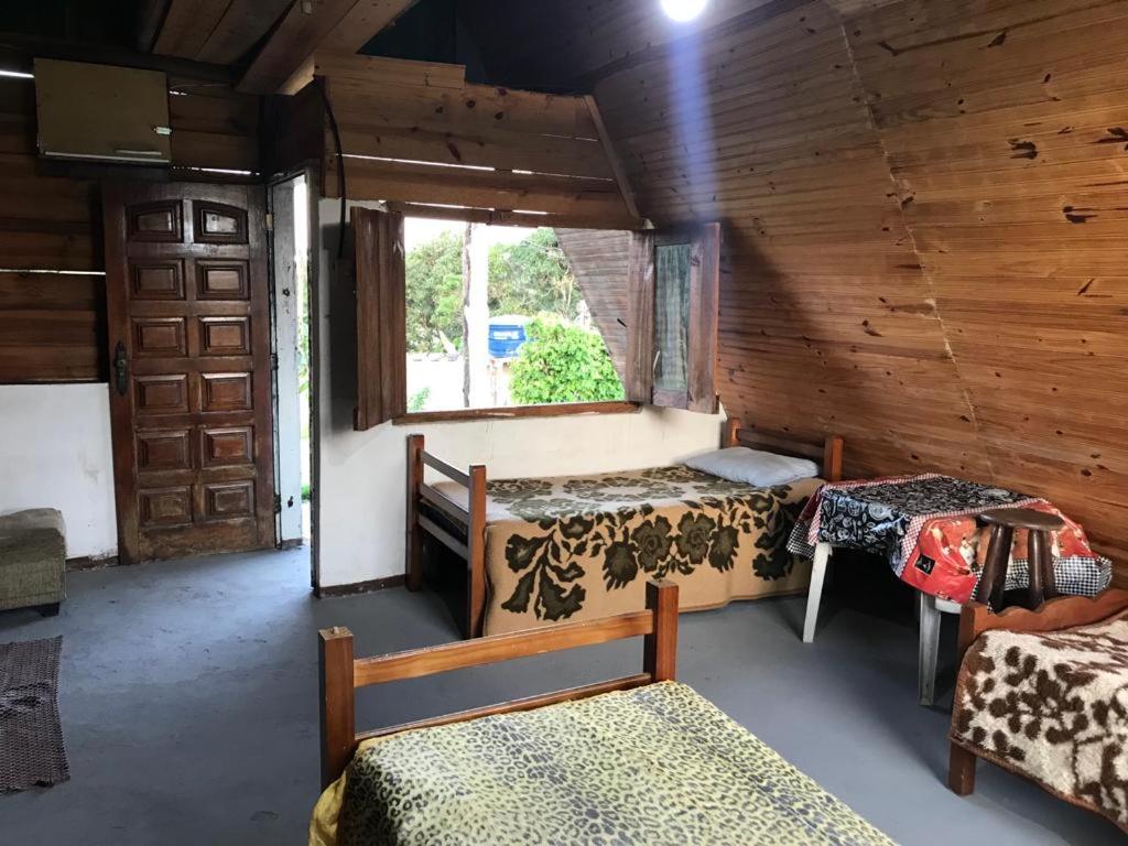 a room with two beds and a window at Chalés Pesqueiro Sitio do Aconchego in Pôrto Feliz