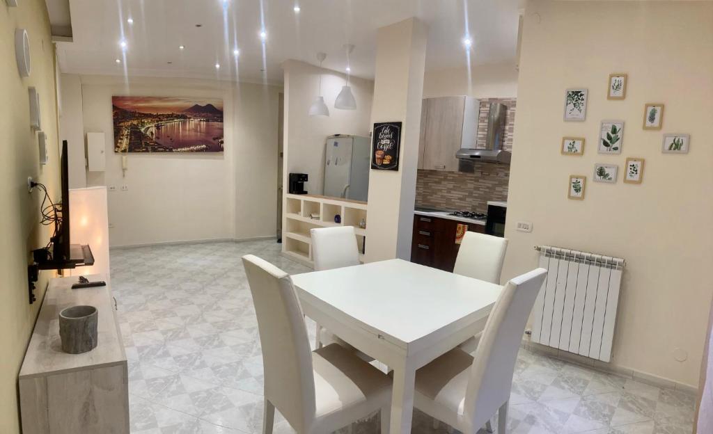 a white dining room with a white table and chairs at sentiti a casa-guest house in Naples