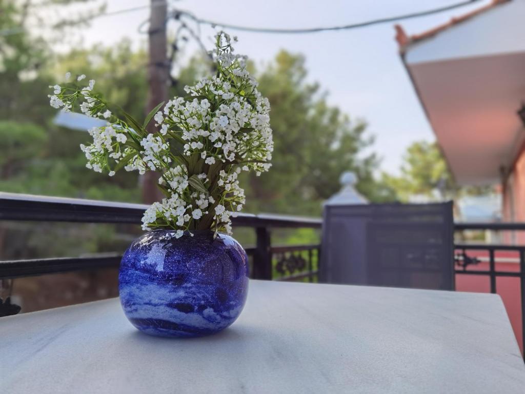 a blue vase with white flowers sitting on a table at Evaggelia's Seaside Boutique Apartment in Ireon
