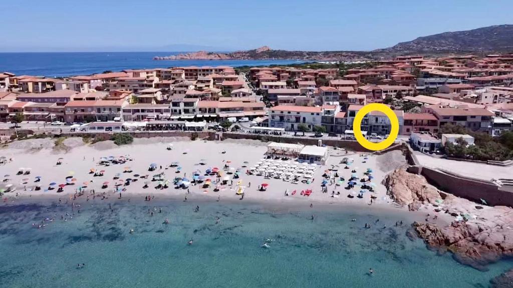 a group of people on a beach with a yellow circle at Casetta al mare in Isola Rossa