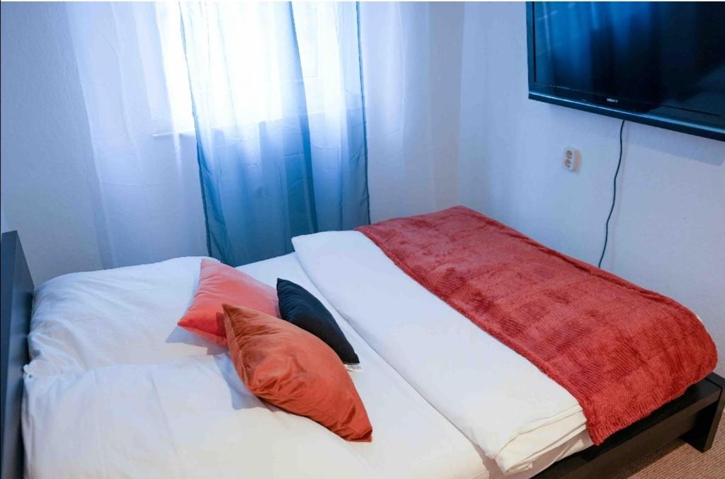 格拉德貝克的住宿－Bequem Privatzimmer in einer Wohnung-Gladbeck，一间卧室配有一张带两个枕头的床和电视。