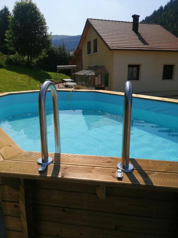 - une piscine avec 2 bars en métal sur une terrasse en bois dans l'établissement Gite de L'ours, à La Bresse
