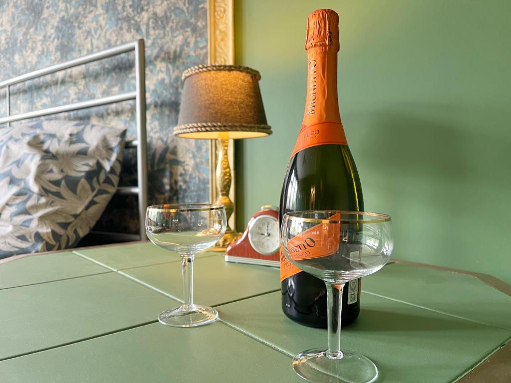 a bottle of wine and two glasses on a table at Apartament Stary Zdrój in Wałbrzych