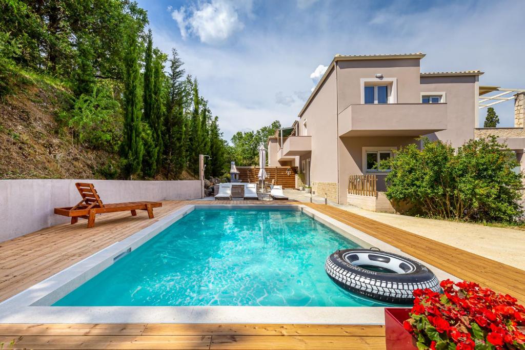 a swimming pool in the backyard of a house at Nightingale Villa & Suites Corfu in Gazátika