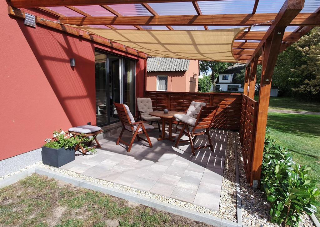 a patio with a table and chairs under a pergola at Wohnung Fewo 4 