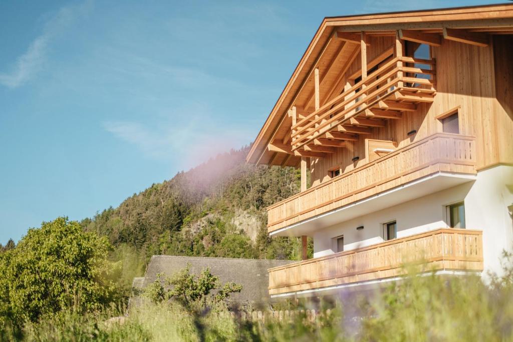 ein Gebäude mit Holzbalkonen an der Seite eines Berges in der Unterkunft Oberhemberger Hof in Feldthurns