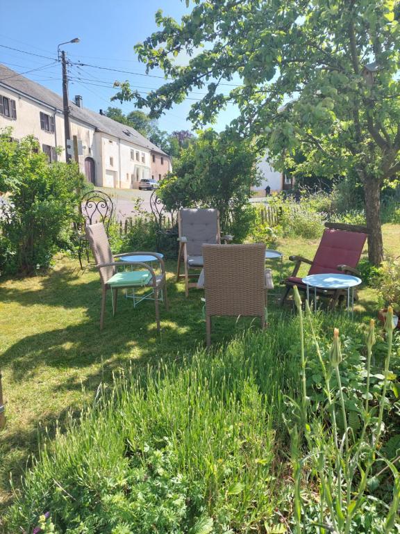 a group of chairs and tables in a yard at B&B A Quiet Place in Rossignol
