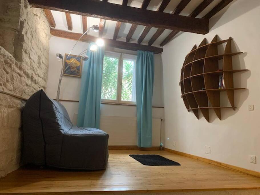 sala de estar con silla negra y ventana en Grand Studio indépendant, en Pignan