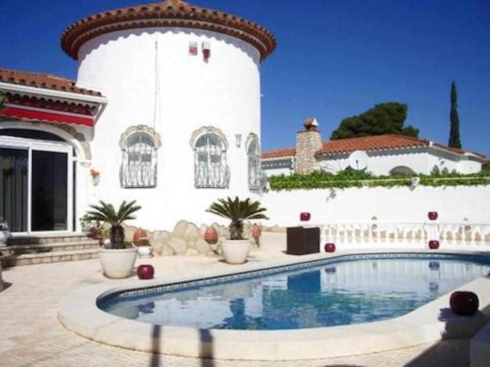 a house with a swimming pool in front of a building at Mooie vrijstaande vakantiewoning met privé-zwembad in Miami Platja