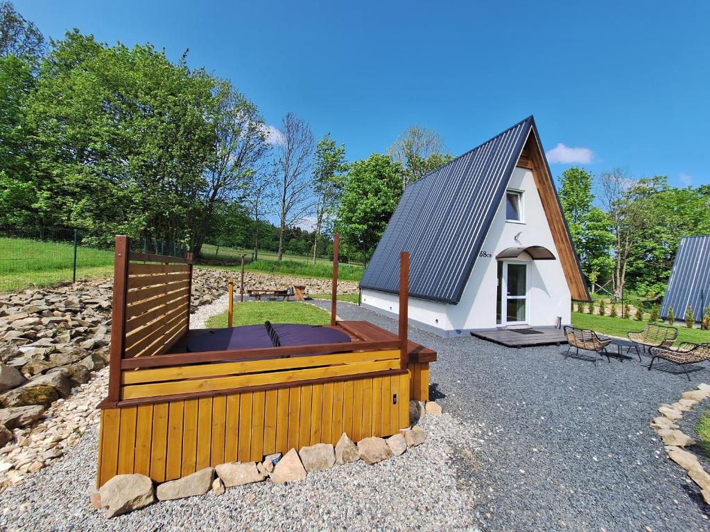 a small house with a hot tub in front of it at Domki na Sudeckiej Polanie in Stronie Śląskie