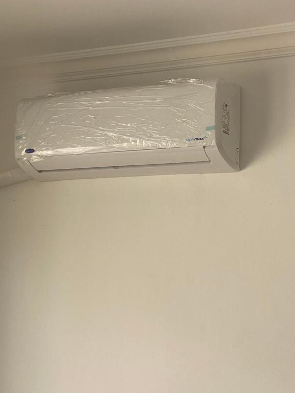 a shelf with a piece of plastic on a wall at Privet room with Ac in an apartment 10 min away from Madinaty in Madīnat ash Shurūq