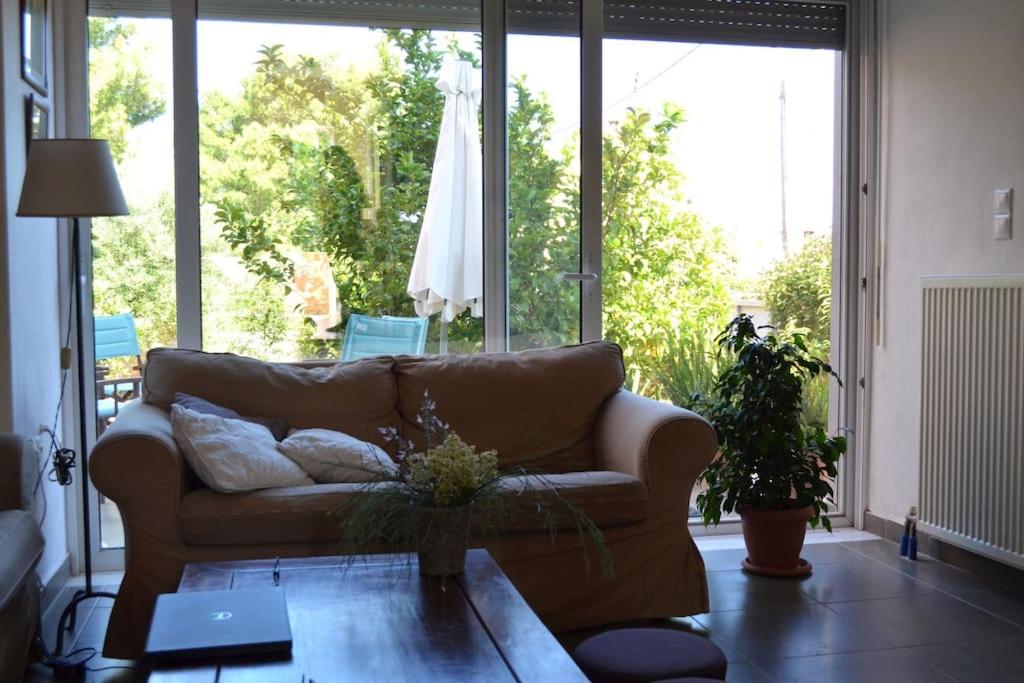 sissy's relaxing villa في أرتيميدا: غرفة معيشة مع أريكة وطاولة