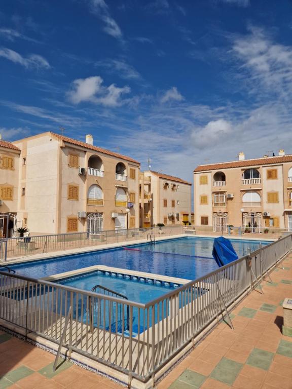 a swimming pool at a resort with buildings at "Vero Vijola" in Torrevieja in Torrevieja