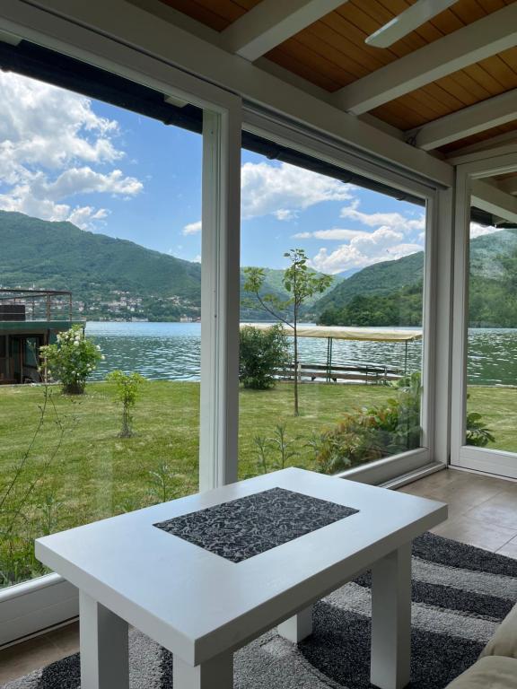 a white table on a screened porch with a view of the water at Vikendica Gorica-Jablaničko jezero in Konjic