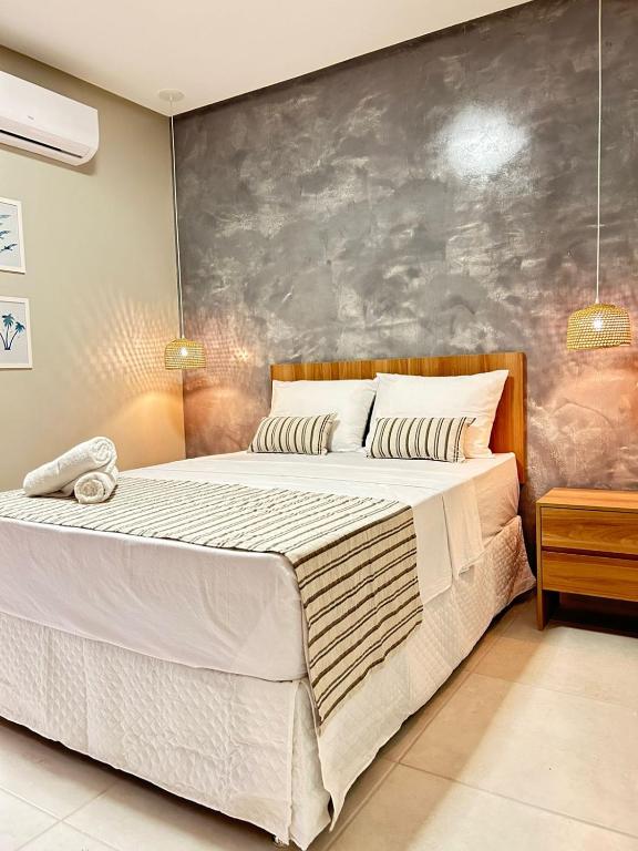 a bedroom with a large bed with a gray wall at Pousada Mares Maragogi in Maragogi