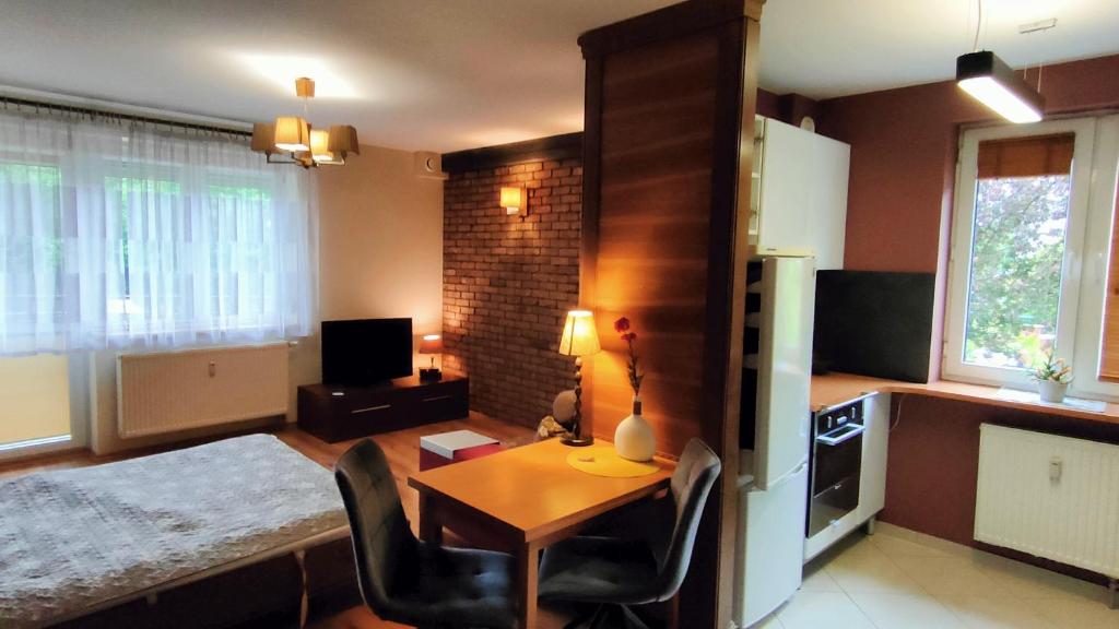 un soggiorno con tavolo e sedie e una cucina di Leśny Apartament a Białystok