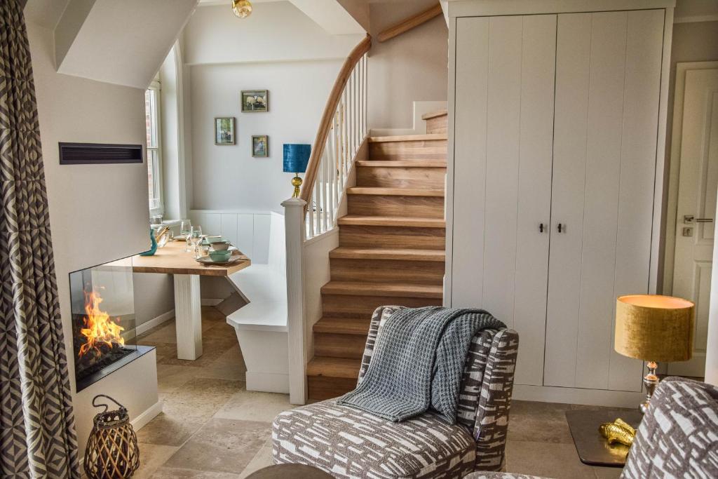 uma sala de estar com escadas, uma cadeira e uma lareira em 3Meeresblick-List em List