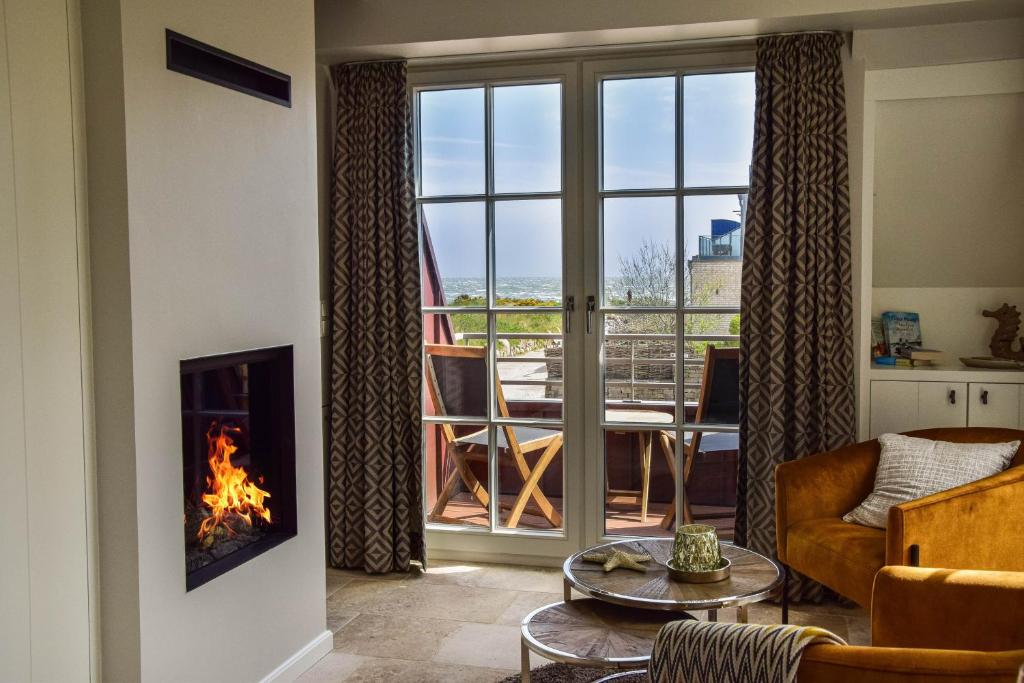 a living room with a fireplace and a view of a balcony at 2Land in Sicht in List