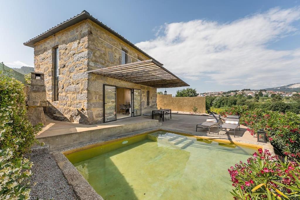 una casa de piedra con una piscina frente a ella en Lemon House, en Valpedre