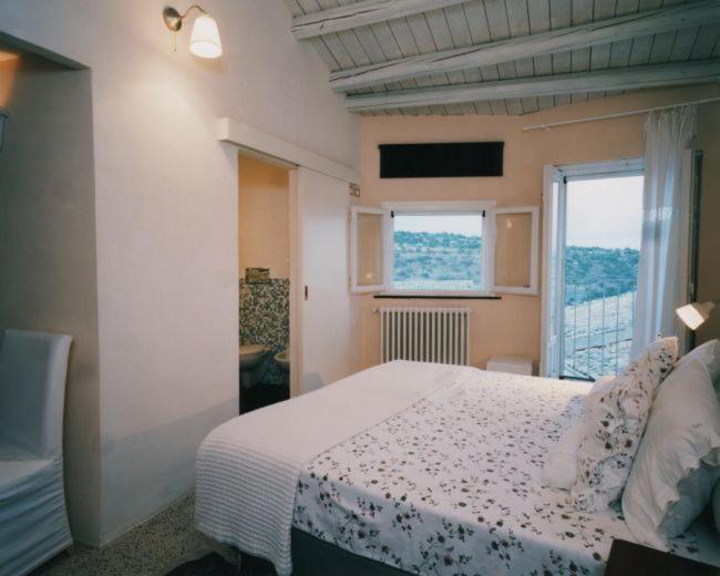 1 dormitorio con cama y ventana grande en Caelum Hyblae, en Ragusa