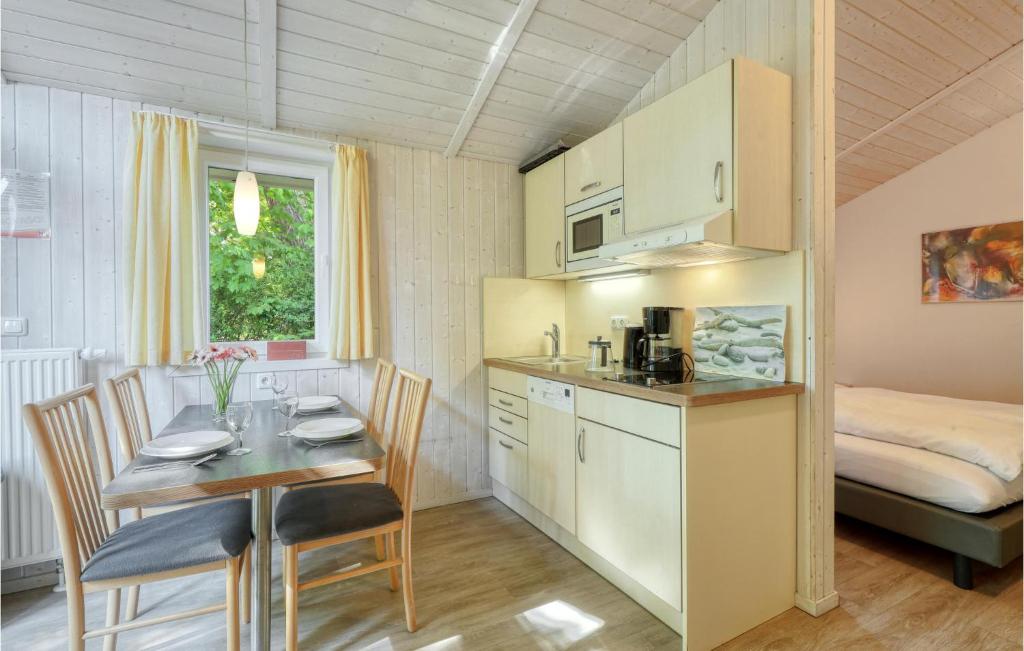 eine Küche und ein Esszimmer mit einem Tisch und einem Bett in der Unterkunft Schmugglerstieg 13c - Dorf 5 in Travemünde